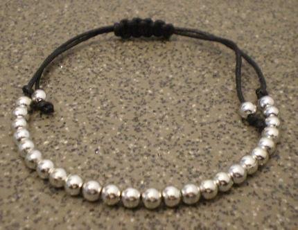 Knyttet armbnd med sm glasperler.